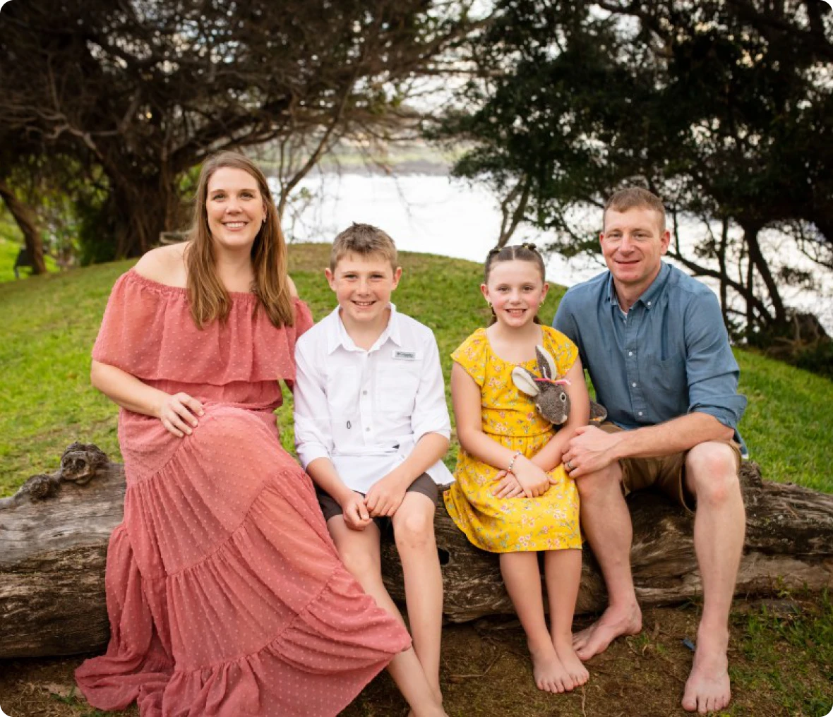 Family sitting on a log outdoors